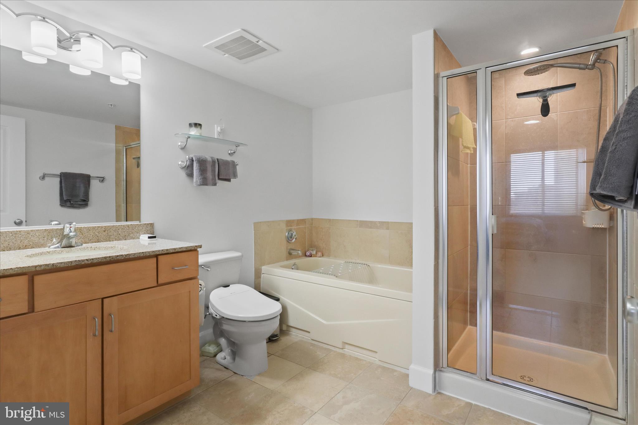 1220 North Fillmore Street, Unit 909 Arlington, VA 22201 - Photo 16 of 38 a bathroom with a bathtub shower sink mirror and toilet