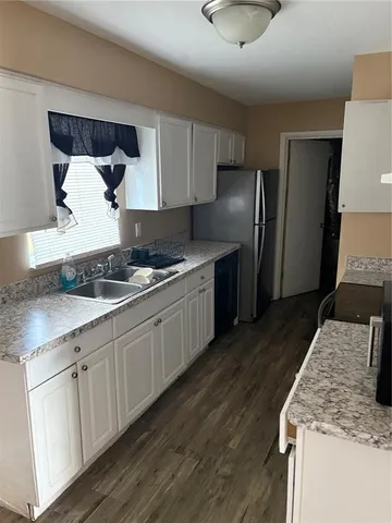 a kitchen with granite countertop a sink stove and refrigerator