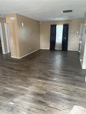 an empty room with wooden floor and entrance