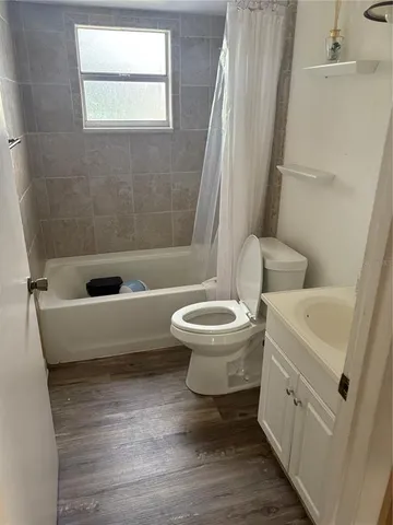 a bathroom with a toilet a sink a mirror and bathtub