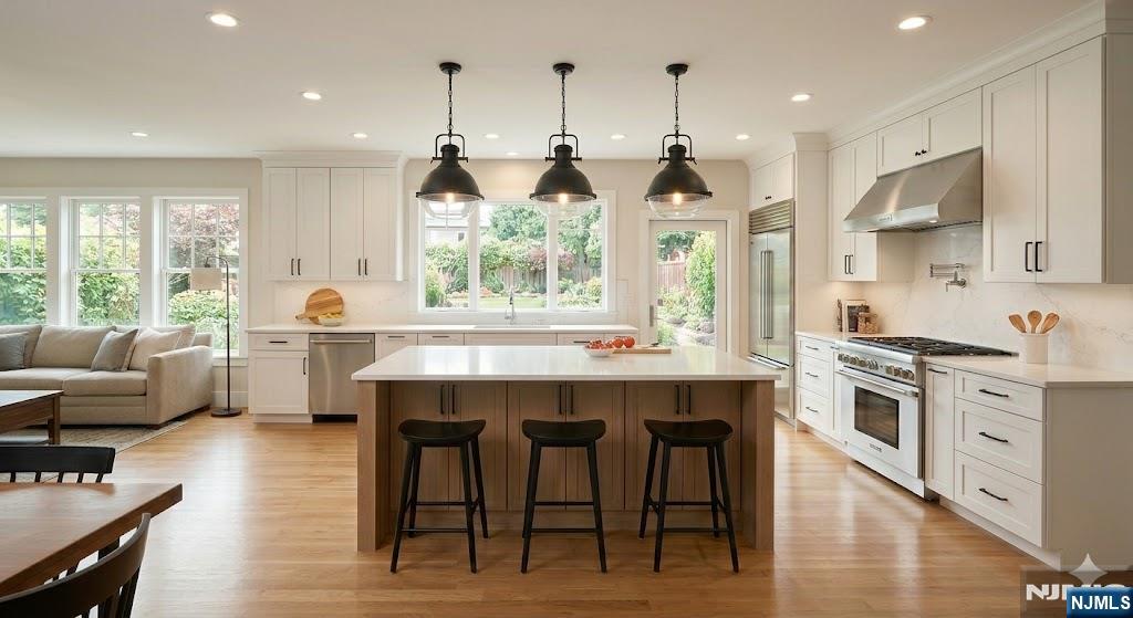 615 Shelton Road Ridgewood, NJ 07450 - Photo 9 of 10 a kitchen with stainless steel appliances granite countertop a stove a sink dishwasher a refrigerator and a dining table with wooden floor