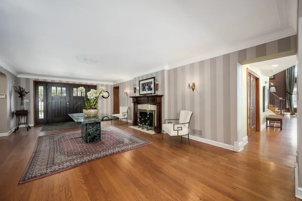 a kitchen with stainless steel appliances a sink a stove a refrigerator cabinets and a dining table with wooden floor