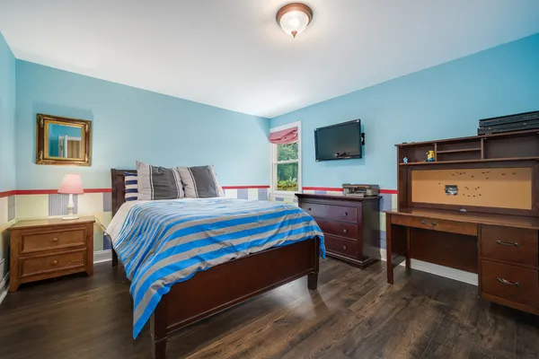 a bed room with a bed and a flat tv screen