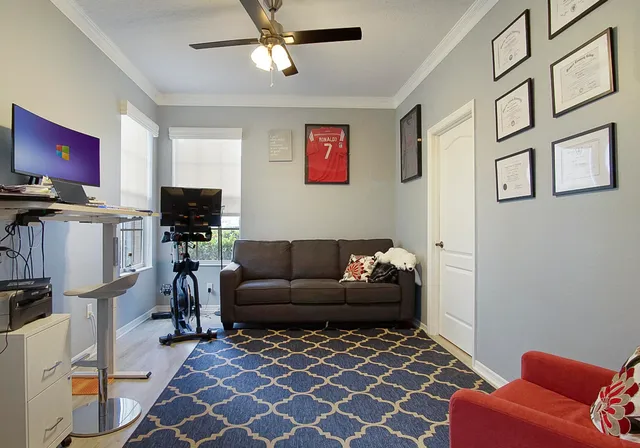 a living room with furniture a flat screen tv and a window