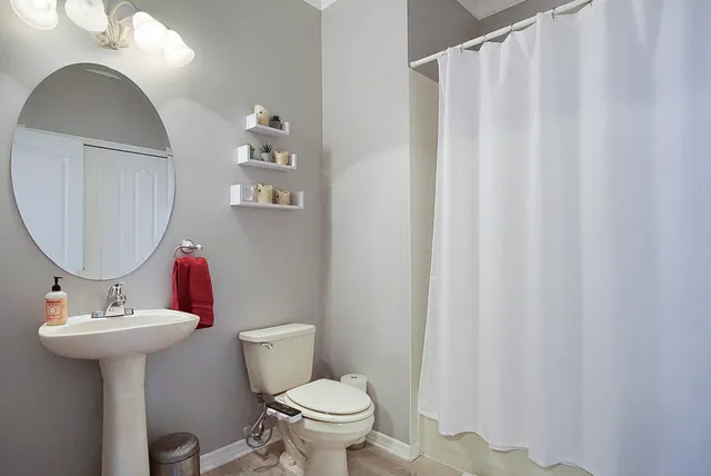 a bathroom with a sink toilet and a mirror