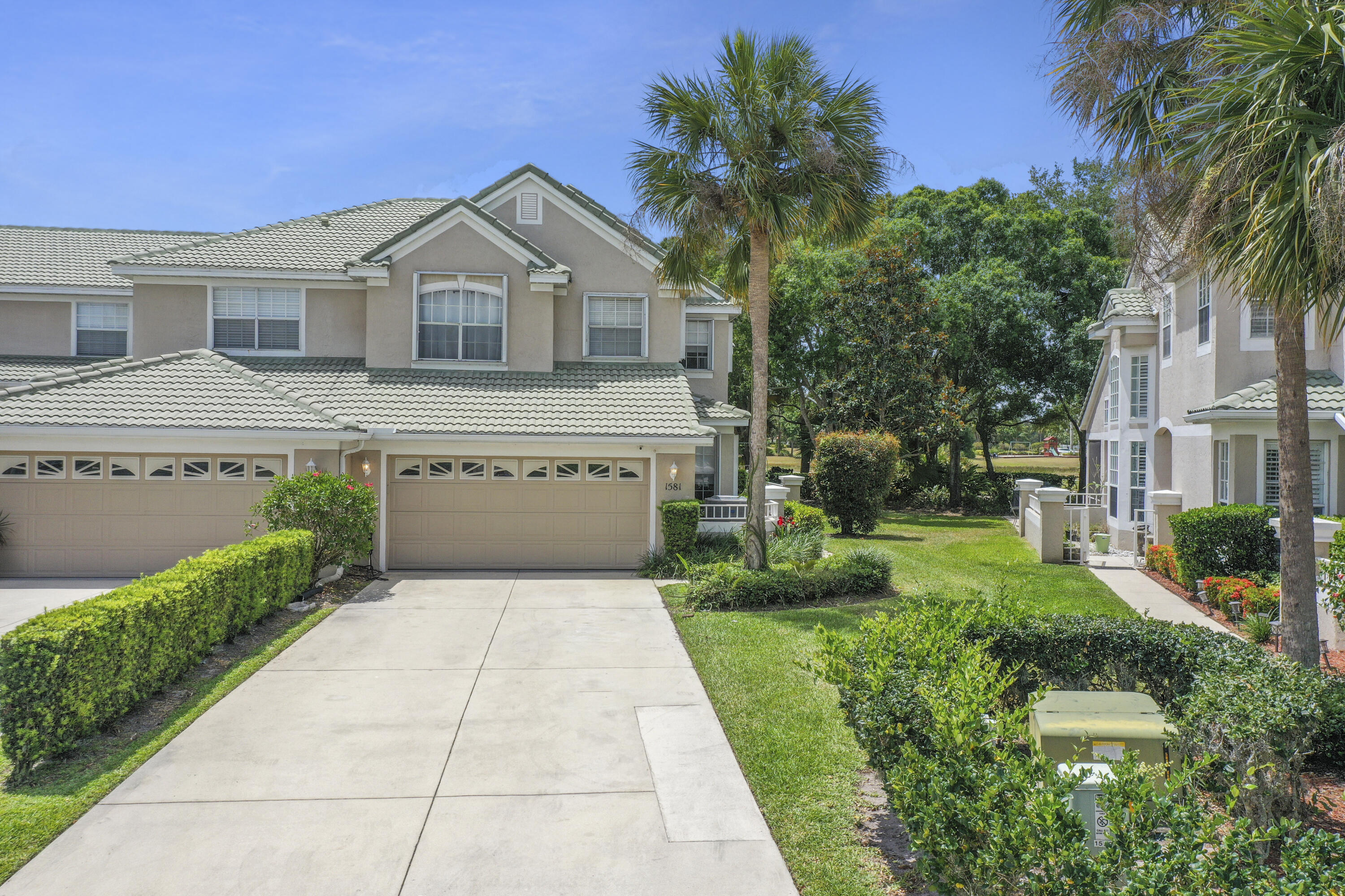1581 Southwest Harbour Isles Circle, Unit 58 Port St. Lucie, FL 34986 - Photo 30 of 38 a front view of a house with a yard and potted plants