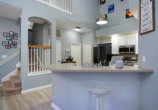 a kitchen with stainless steel appliances granite countertop a sink and a refrigerator