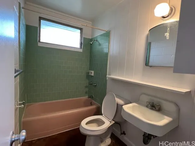 a bathroom with a sink toilet mirror and bathtub