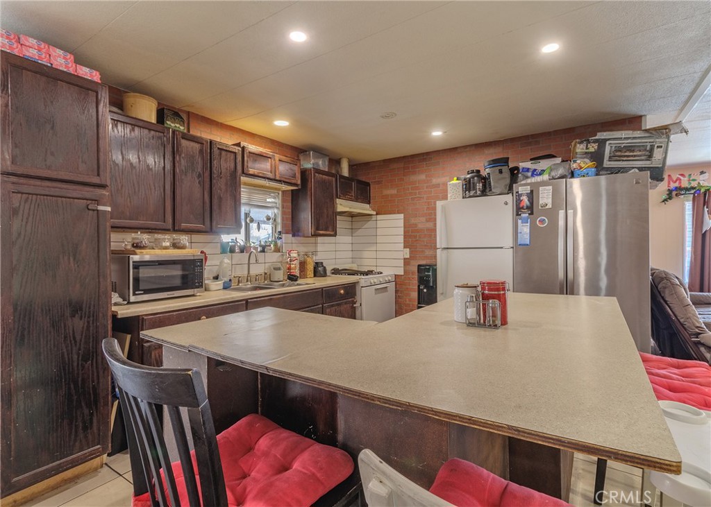 1616 South Euclid Street Anaheim, CA 92804 - Photo 3 of 22 a kitchen with refrigerator a sink and chairs