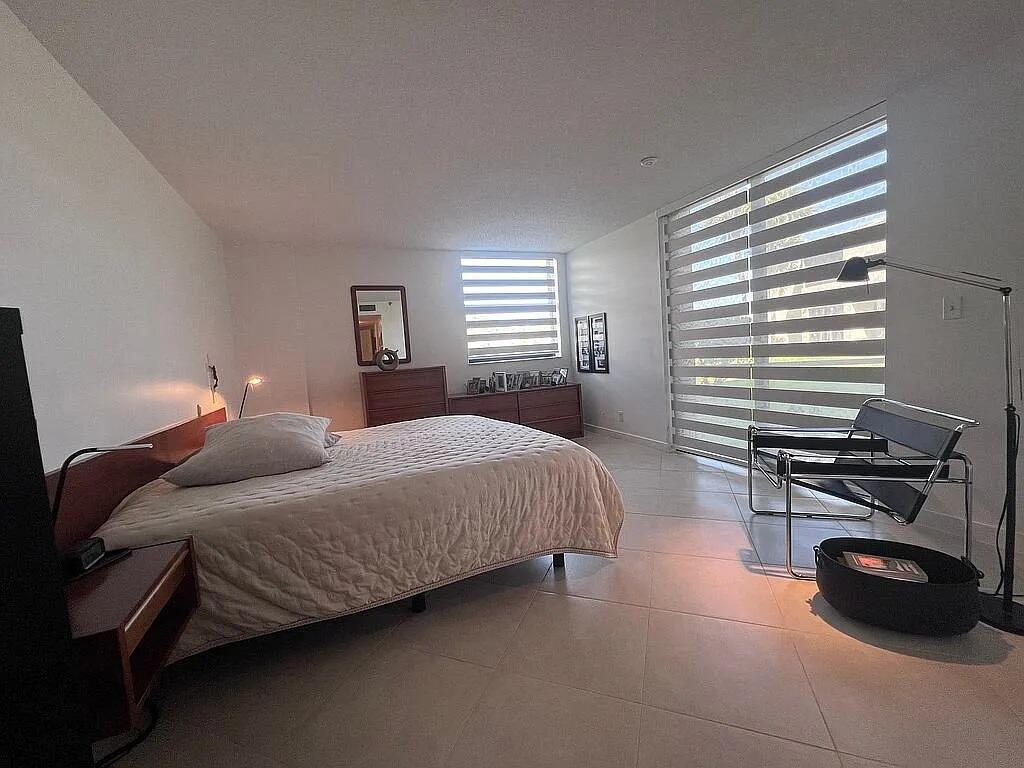 6463 La Costa Drive, Unit 105 Boca Raton, FL 33433 - Photo 29 of 40 a bedroom with a bed a table and a window