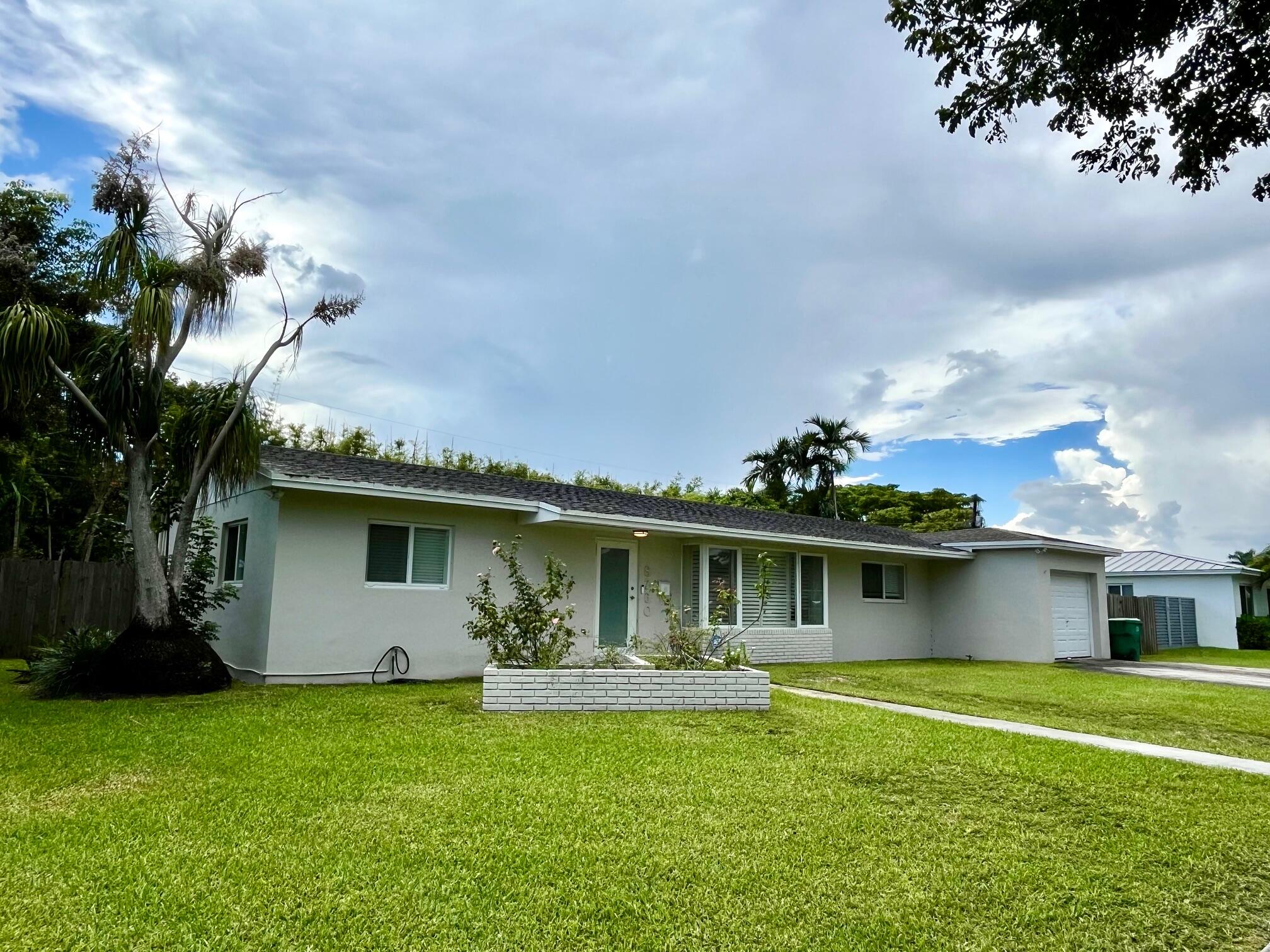 8760 Southwest 83rd Street Miami, FL 33173 - Photo 1 of 24 a front view of a house with garden