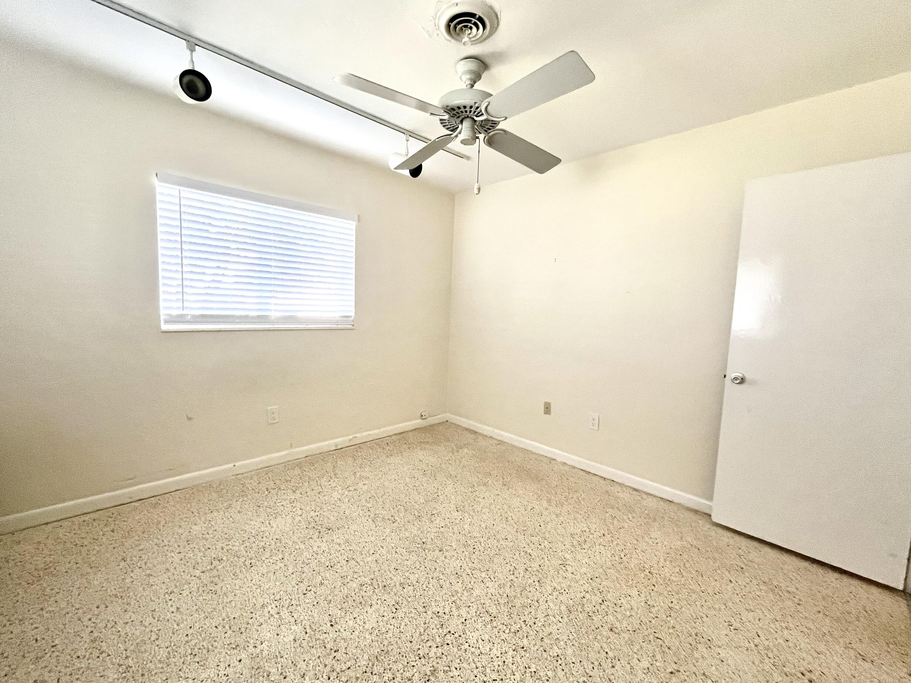 8760 Southwest 83rd Street Miami, FL 33173 - Photo 18 of 24 an empty room with a window and a ceiling fan