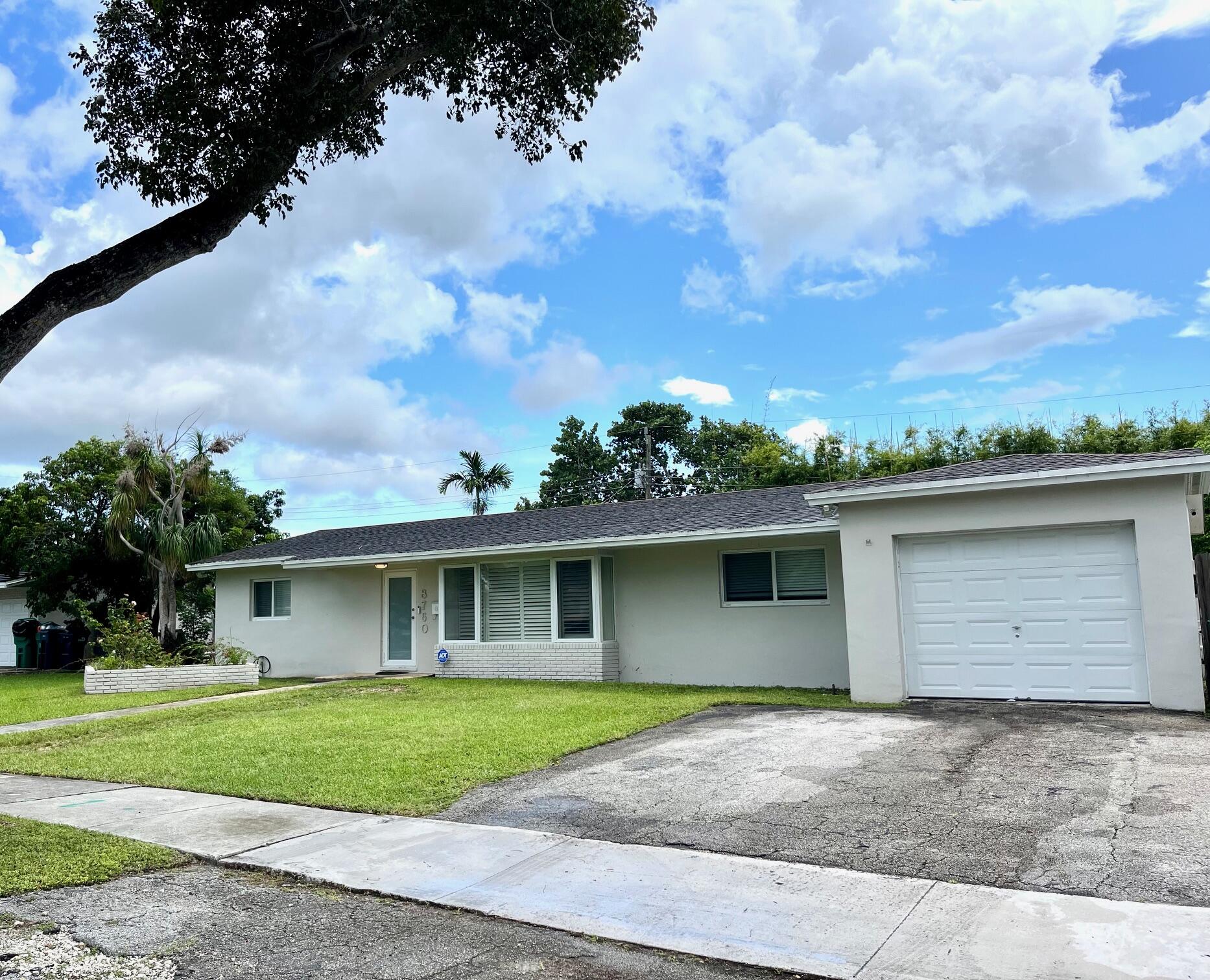 8760 Southwest 83rd Street Miami, FL 33173 - Photo 2 of 24 a view of a house with a yard and garage