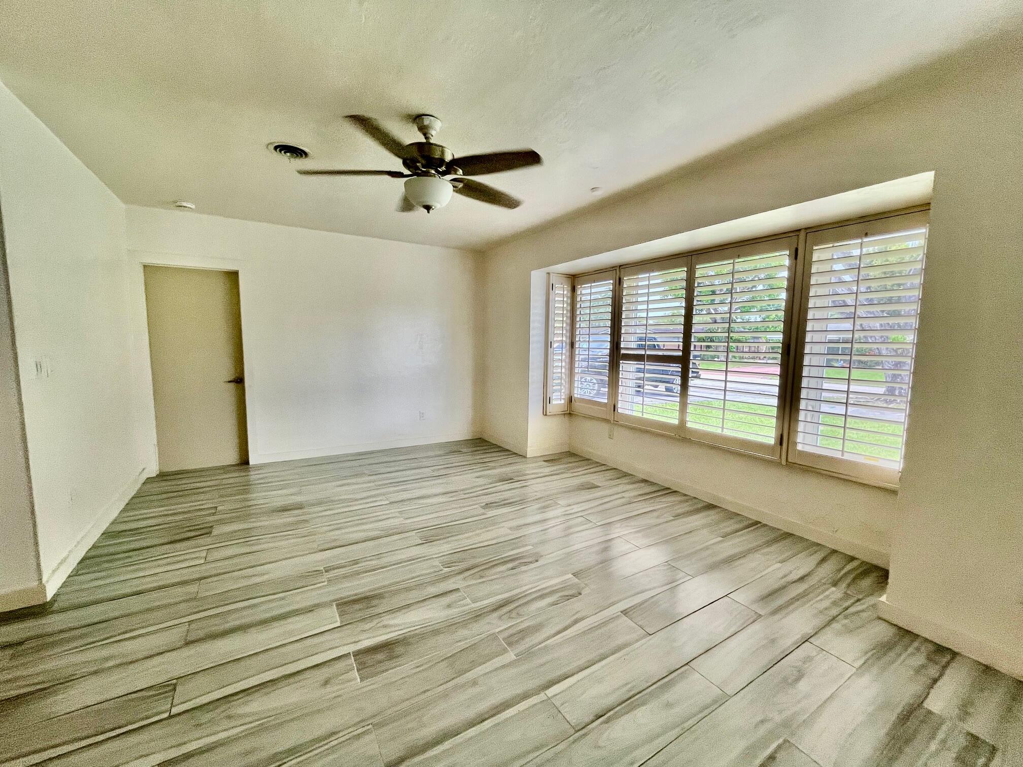 8760 Southwest 83rd Street Miami, FL 33173 - Photo 3 of 24 a view of an empty room with a window and wooden floor