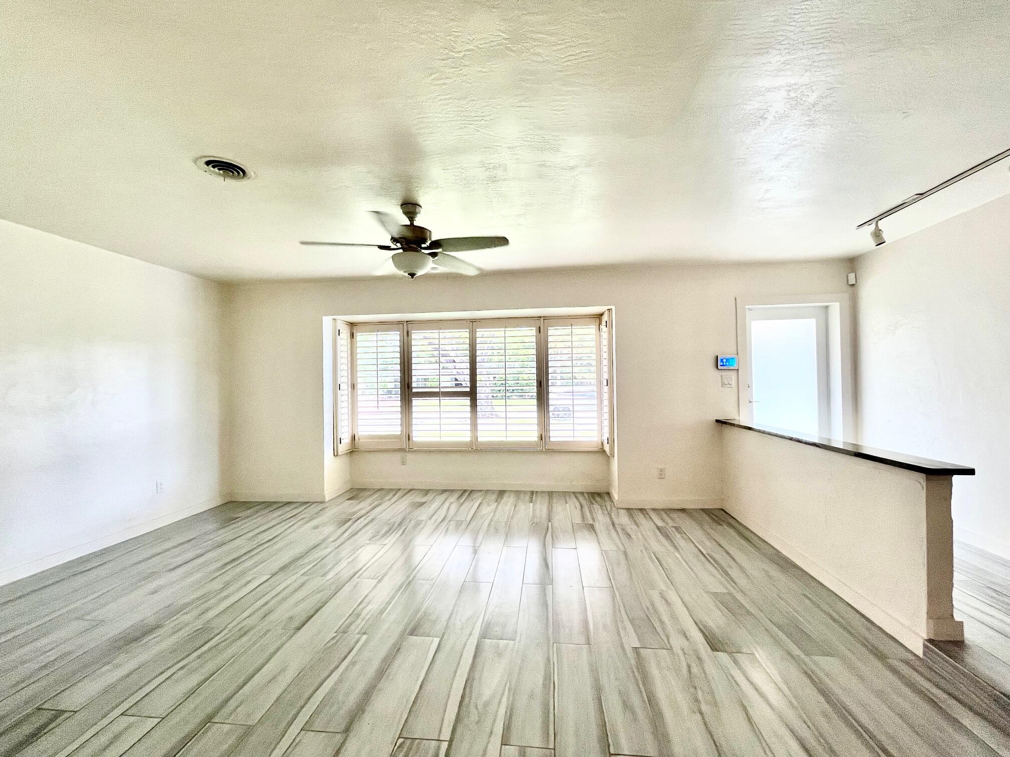 8760 Southwest 83rd Street Miami, FL 33173 - Photo 4 of 24 a view of an empty room with a window and wooden floor