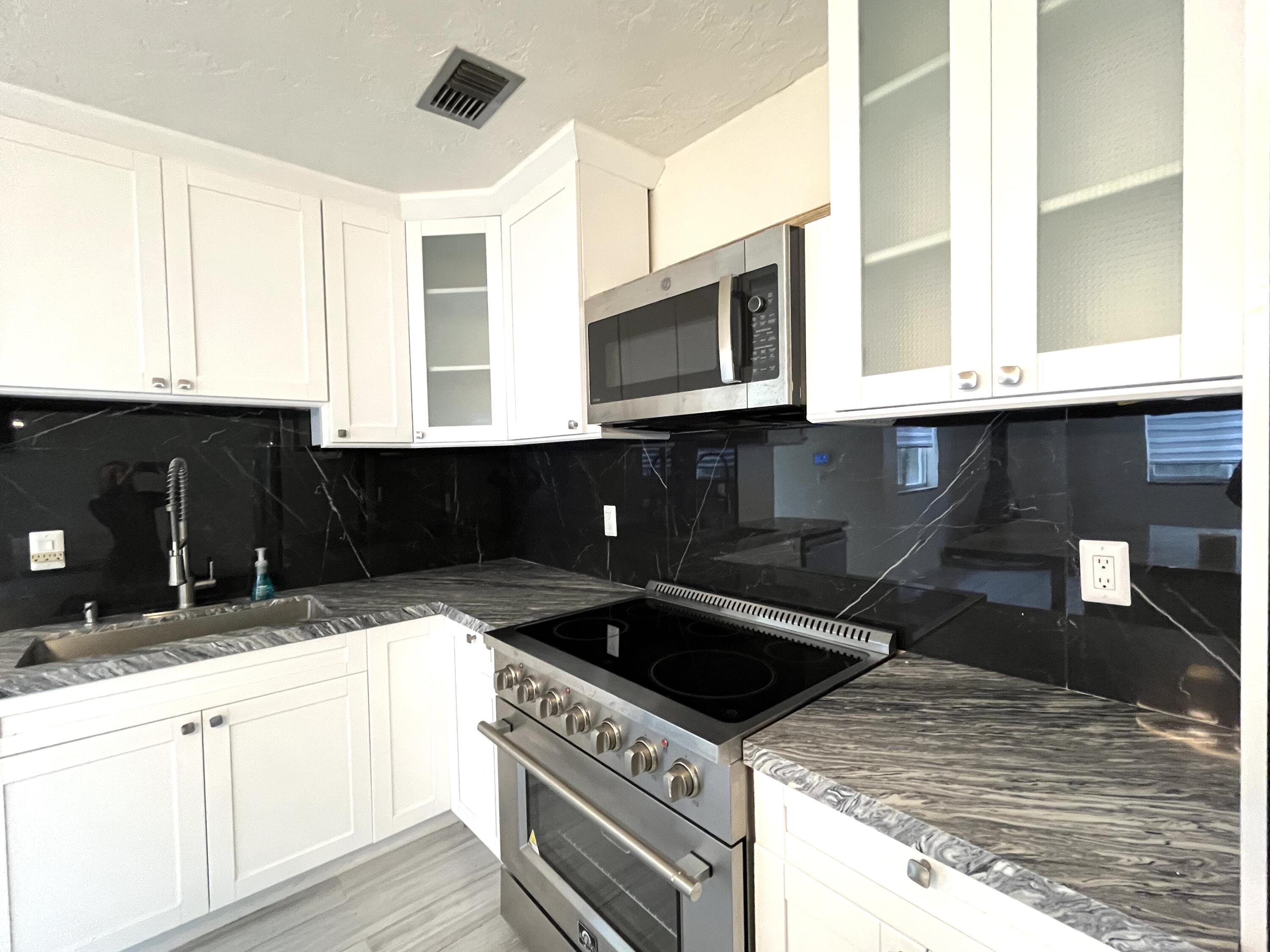 8760 Southwest 83rd Street Miami, FL 33173 - Photo 6 of 24 a kitchen with granite countertop a stove and a sink