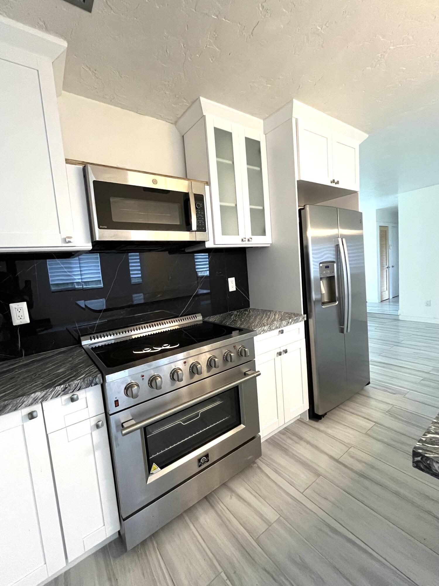 8760 Southwest 83rd Street Miami, FL 33173 - Photo 7 of 24 a kitchen with stainless steel appliances granite countertop a stove a microwave and a refrigerator