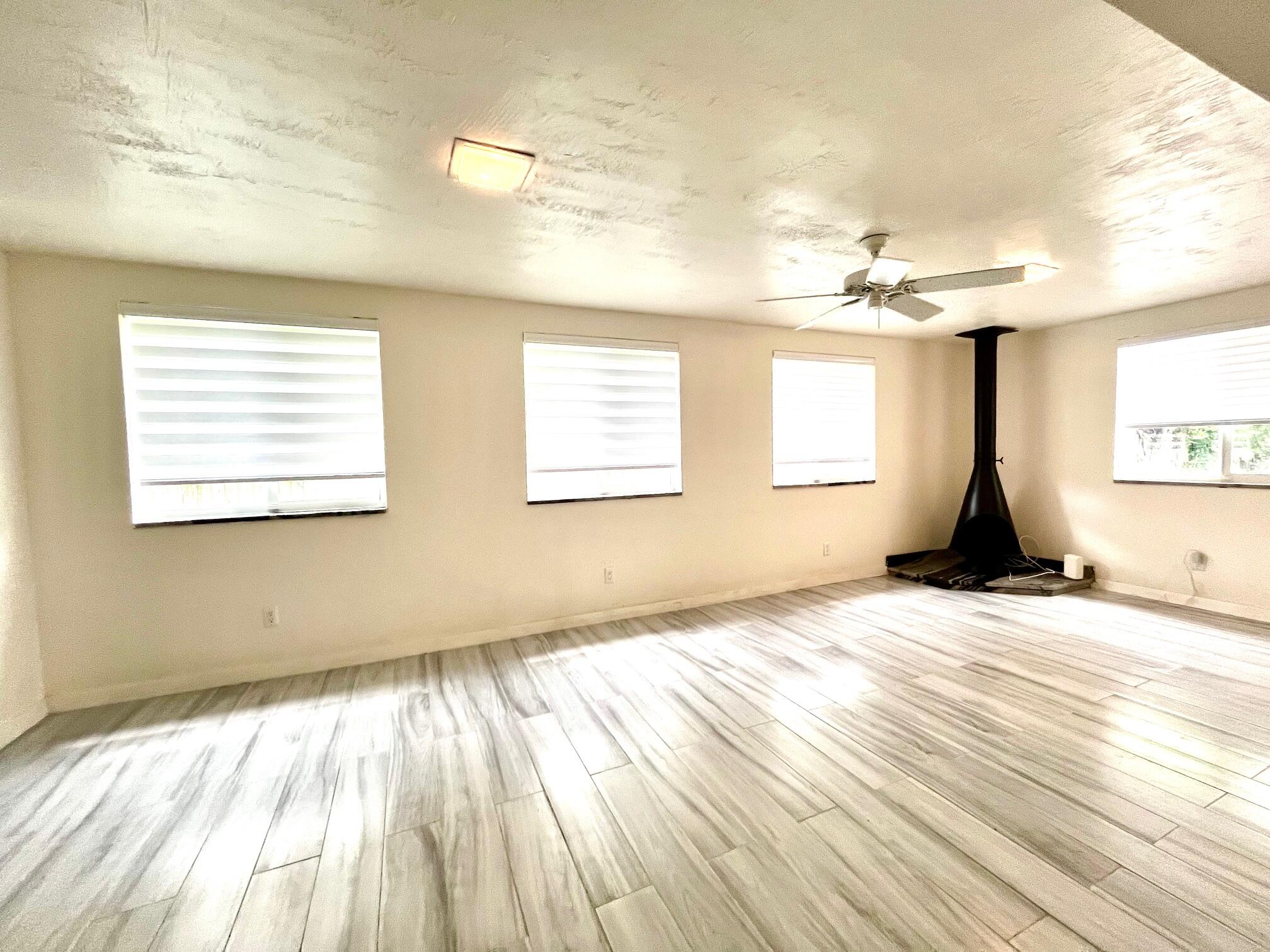 8760 Southwest 83rd Street Miami, FL 33173 - Photo 9 of 24 a view of empty room with wooden floor and fan