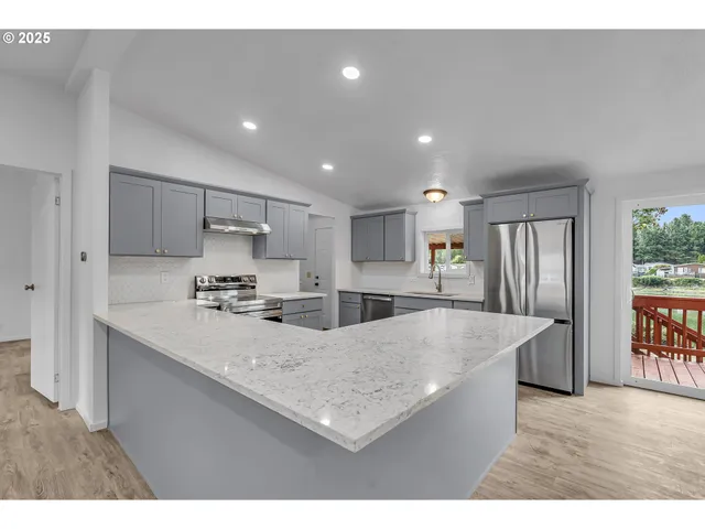 a kitchen with granite countertop a sink and a wooden floor
