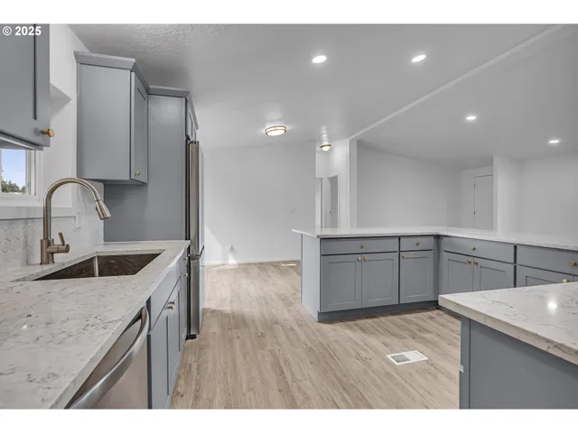 a kitchen with kitchen island a sink stainless steel appliances and cabinets