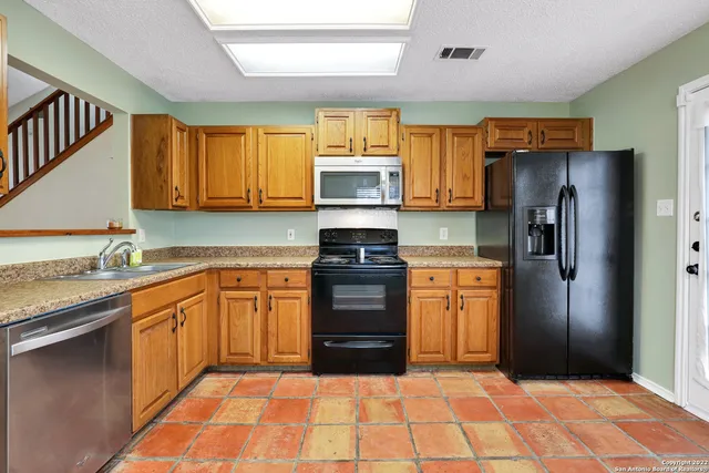 a kitchen with granite countertop stainless steel appliances and wooden cabinets