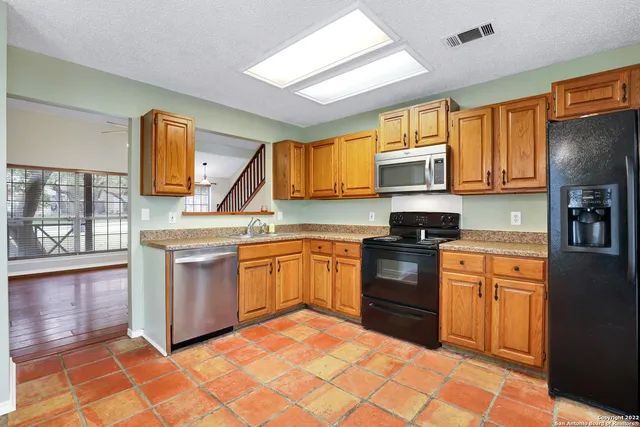 a kitchen with stainless steel appliances granite countertop a stove sink and cabinets
