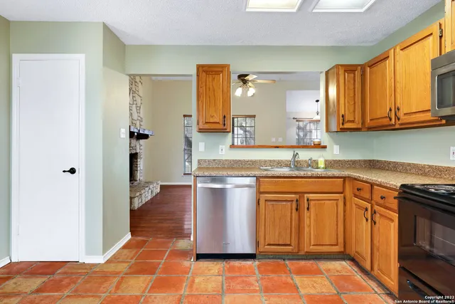 a kitchen with stainless steel appliances granite countertop a refrigerator and a stove top oven