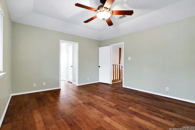 an empty room with wooden floor a ceiling fan and closet