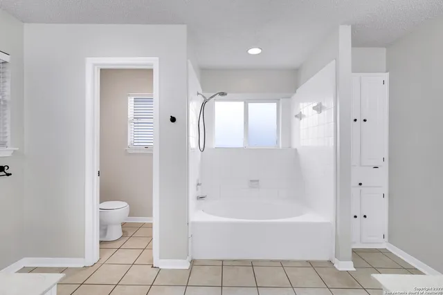a spacious bathroom with a bathtub and toilet