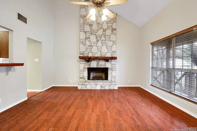a view of empty room with wooden floor and fireplace