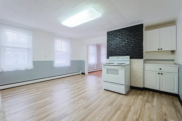 a kitchen with wooden floors and white appliances