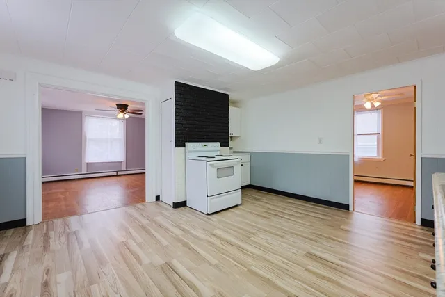 a view of a kitchen with wooden floor and electronic appliances