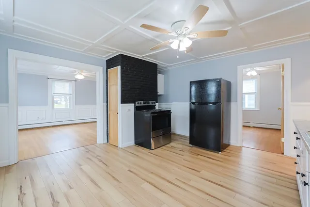 a view of a kitchen with wooden floor and a refrigerator