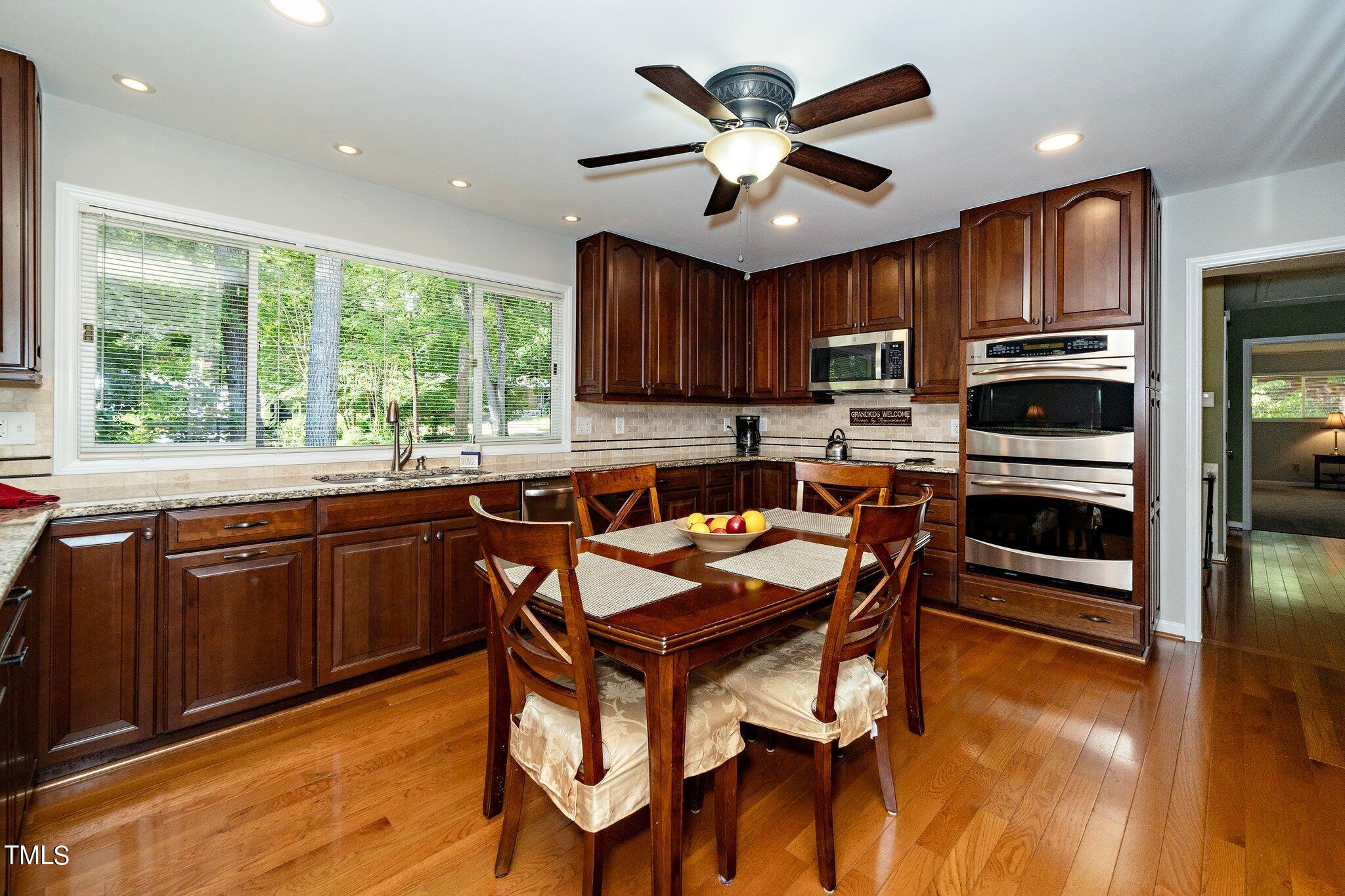 6406 Arnold Road Raleigh, NC 27607 - Photo 22 of 44 a kitchen with stainless steel appliances granite countertop wooden cabinets a stove a sink a dining table and chairs