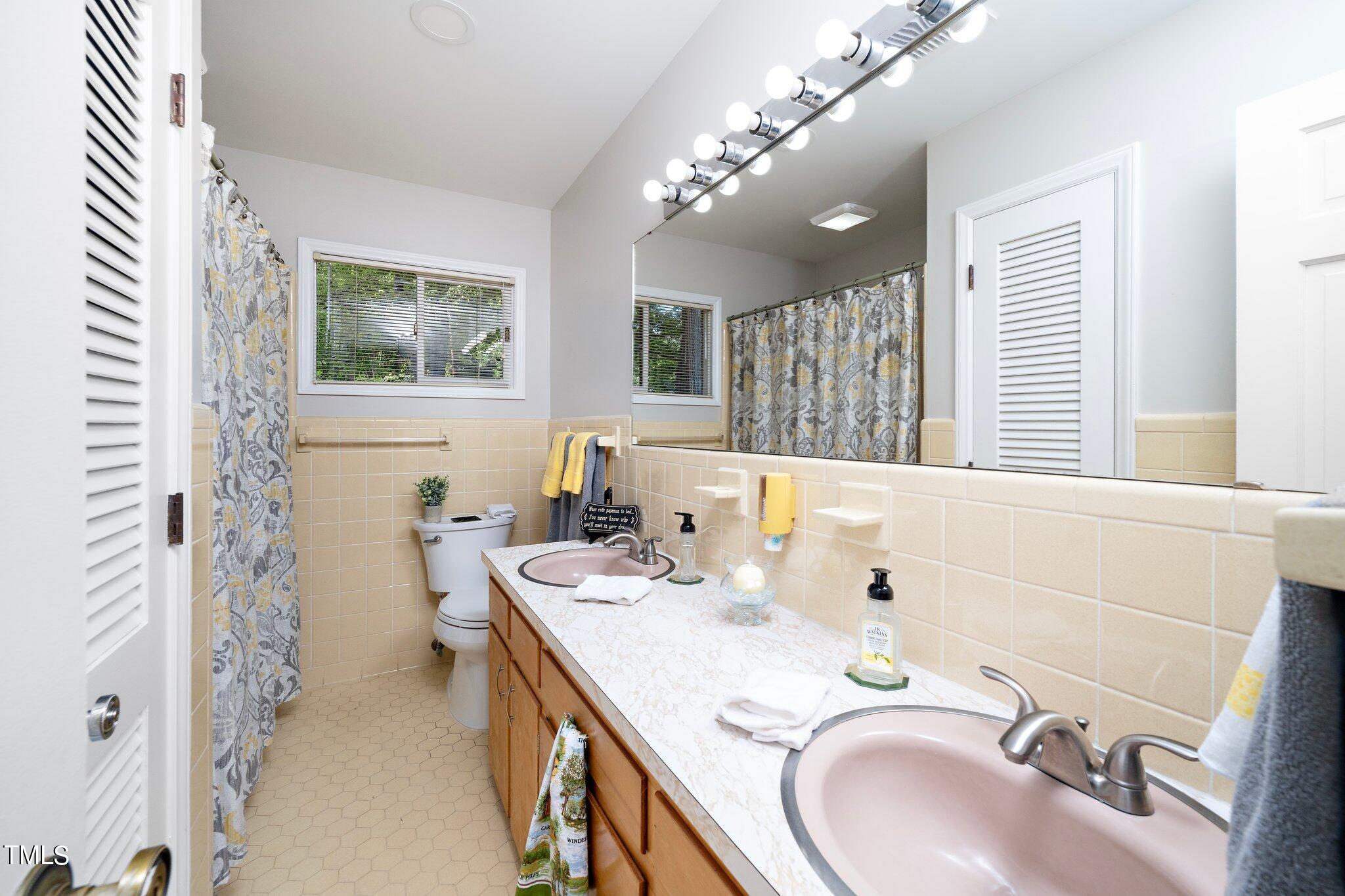 6406 Arnold Road Raleigh, NC 27607 - Photo 29 of 44 a bathroom with a granite countertop sink a large mirror and a shower
