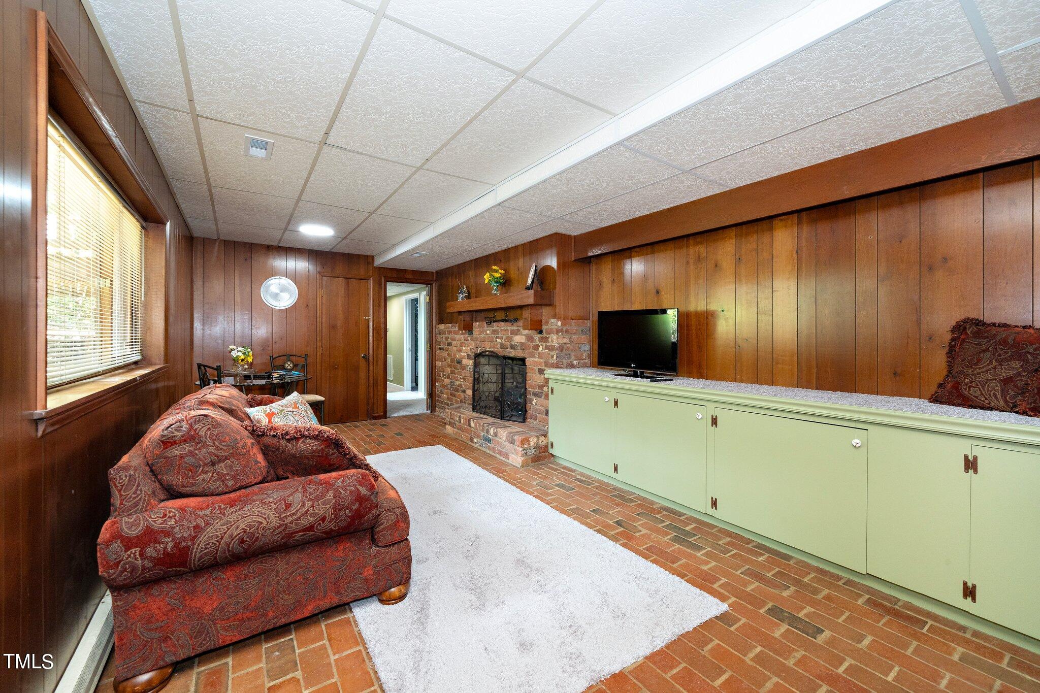 6406 Arnold Road Raleigh, NC 27607 - Photo 43 of 44 a living room with furniture a flat screen tv and a fireplace