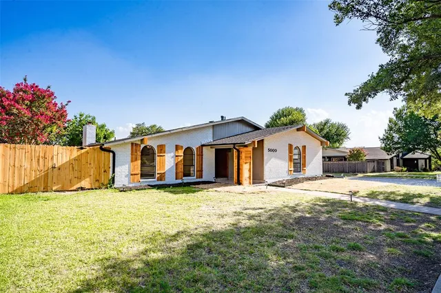 a big house with a big yard and large trees