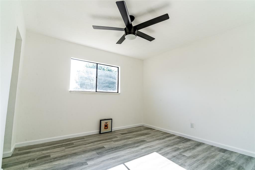 5000 Brandenburg Lane The Colony, TX 75056 - Photo 14 of 14 an empty room with wooden floor fan and windows