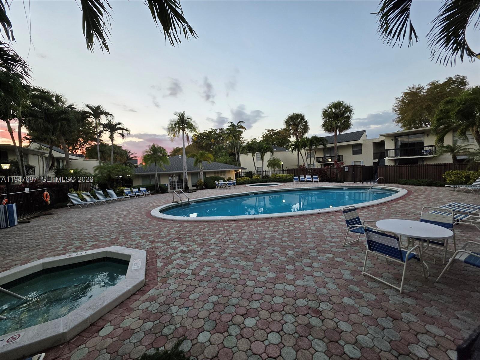 8307 Southwest 142nd Avenue, Unit E108 Miami, FL 33183 - Photo 3 of 22 a swimming pool with outdoor seating yard and barbeque oven