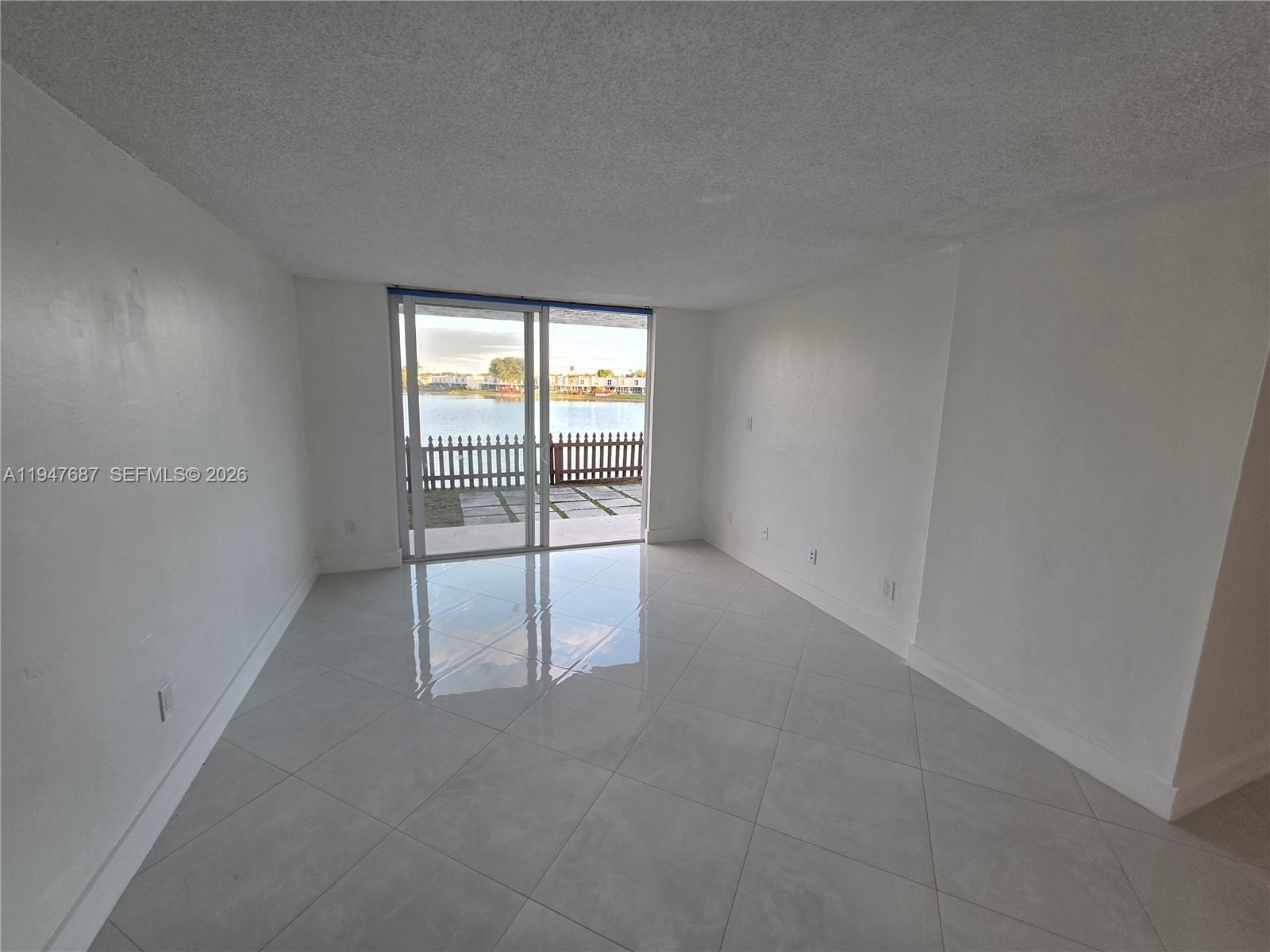 8307 Southwest 142nd Avenue, Unit E108 Miami, FL 33183 - Photo 6 of 22 wooden floor in an empty room with a window