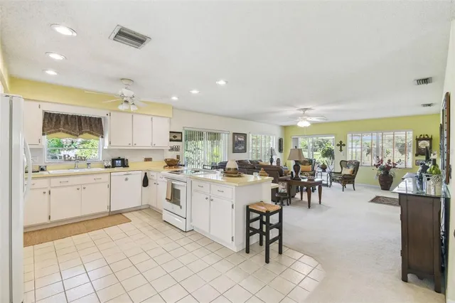 a kitchen with cabinets and chairs