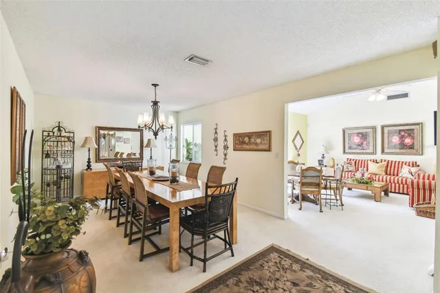 a dining room with furniture a rug a flat screen tv and a couch