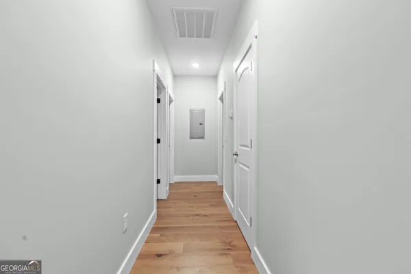 a view of a hallway with wooden floor