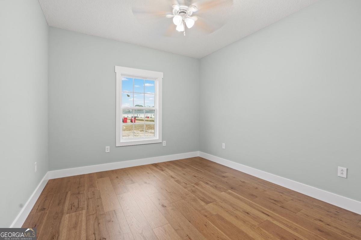 596 Beach Road Baxley, GA 31513 - Photo 16 of 17 wooden floor in an empty room with a window