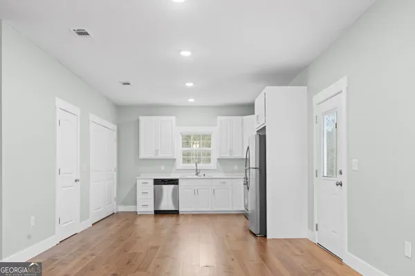 a kitchen with stainless steel appliances a refrigerator sink and cabinets