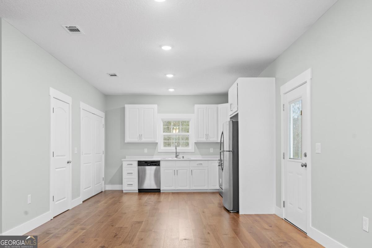 596 Beach Road Baxley, GA 31513 - Photo 4 of 17 a kitchen with stainless steel appliances a refrigerator sink and cabinets
