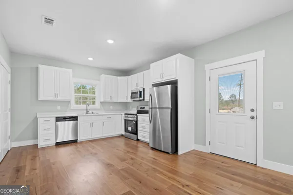 a kitchen with a refrigerator and a stove top oven