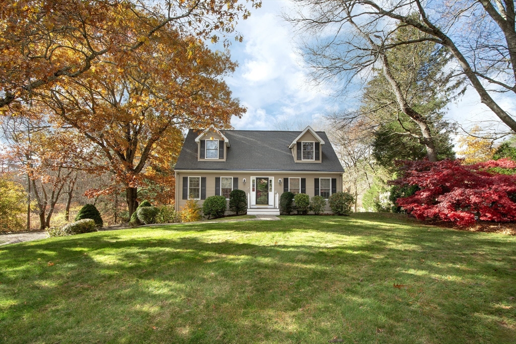 a view of a house with a big yard and large trees