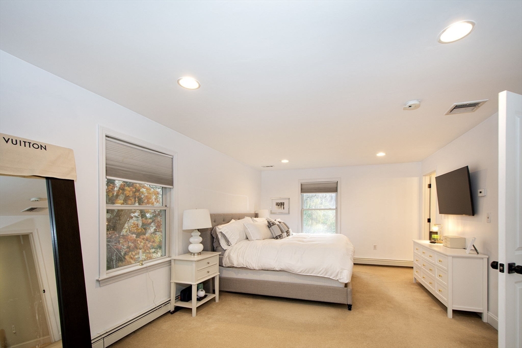 21 Union Street Marshfield, MA 02050 - Photo 18 of 31 a spacious bedroom with a large bed and a flat tv screen