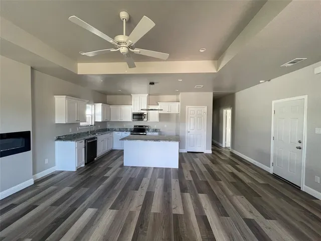 a large kitchen with stainless steel appliances kitchen island a large counter space a sink and cabinets